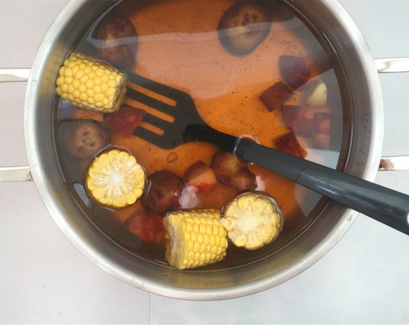 step 3 Cook the potatoes and sausages for six minutes. Chop the Corn (1 ear) in smaller bits and add it to the hot water.