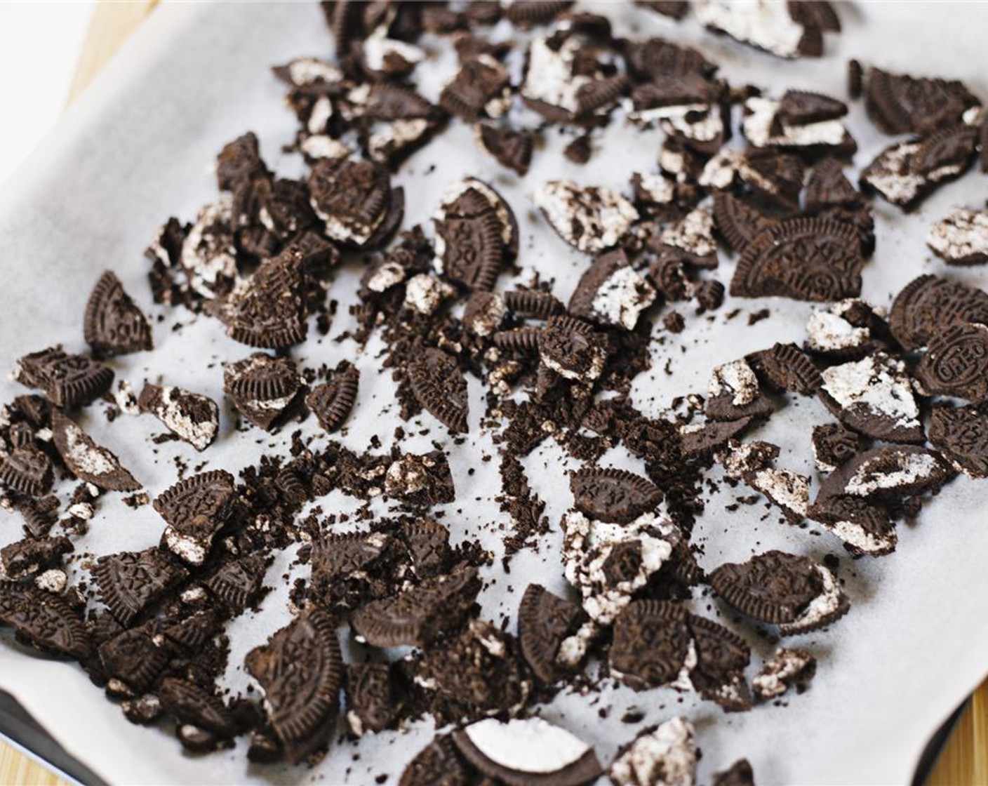 step 3 Line a baking tin with wax paper. Lightly crush the Oreo® Chocolate Sandwich Cookies (1 pckg) and evenly spread on the bottom of the lined tin.