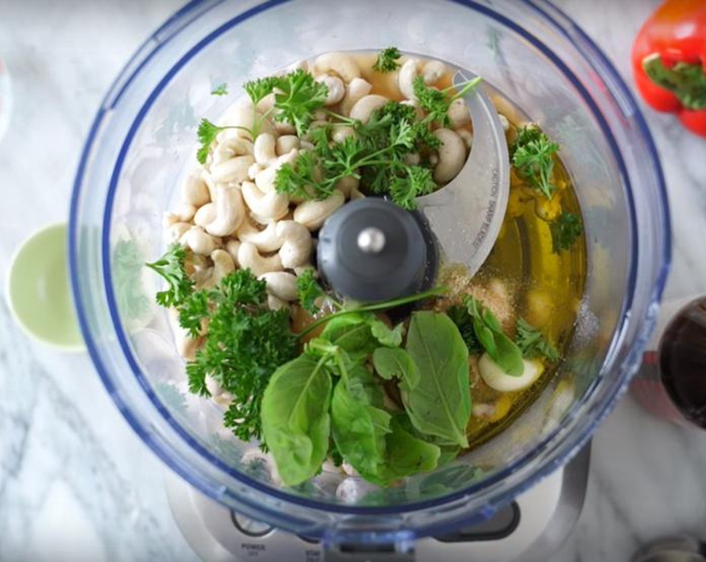 step 1 Combine Raw Cashews (1 1/2 cups), the juice from Lemon (1), Apple Cider Vinegar (1/3 cup), Extra-Virgin Olive Oil (1/3 cup), Honey (2 Tbsp), Onion Powder (1 Tbsp), Garlic (2 cloves), Fresh Basil (1/4 cup), and Fresh Parsley (1/4 cup) in a blender.