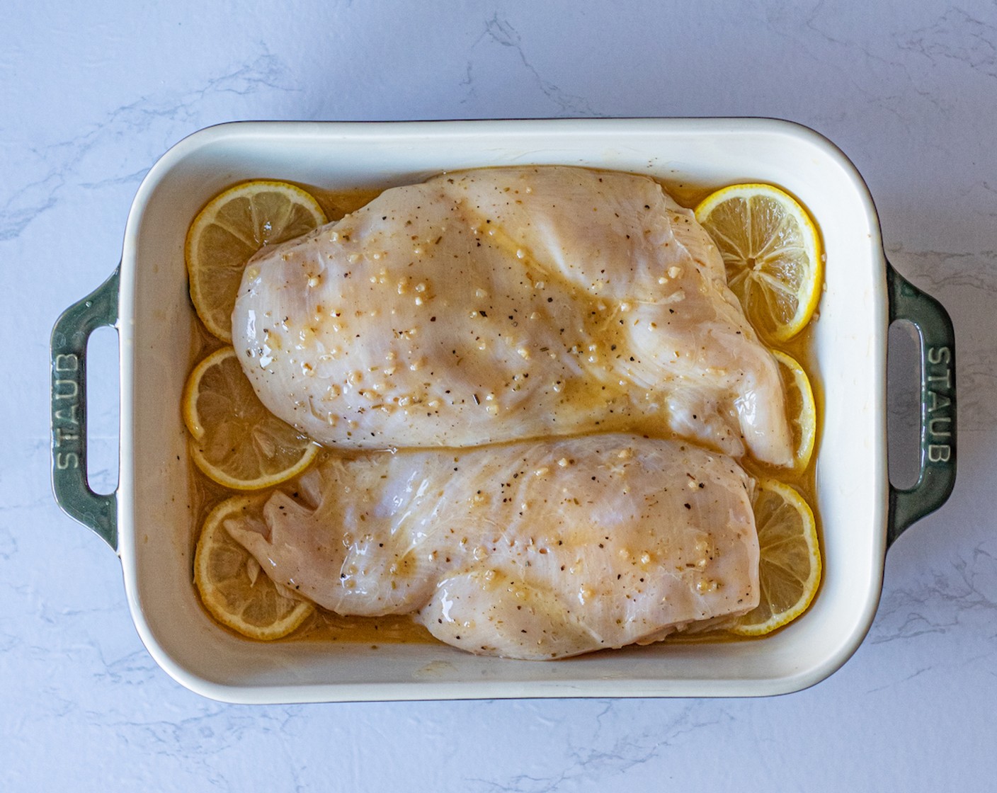 step 3 Tuck the Lemon (1) around the edges of the baking dish making sure that one-half of the slices are under the chicken breast.