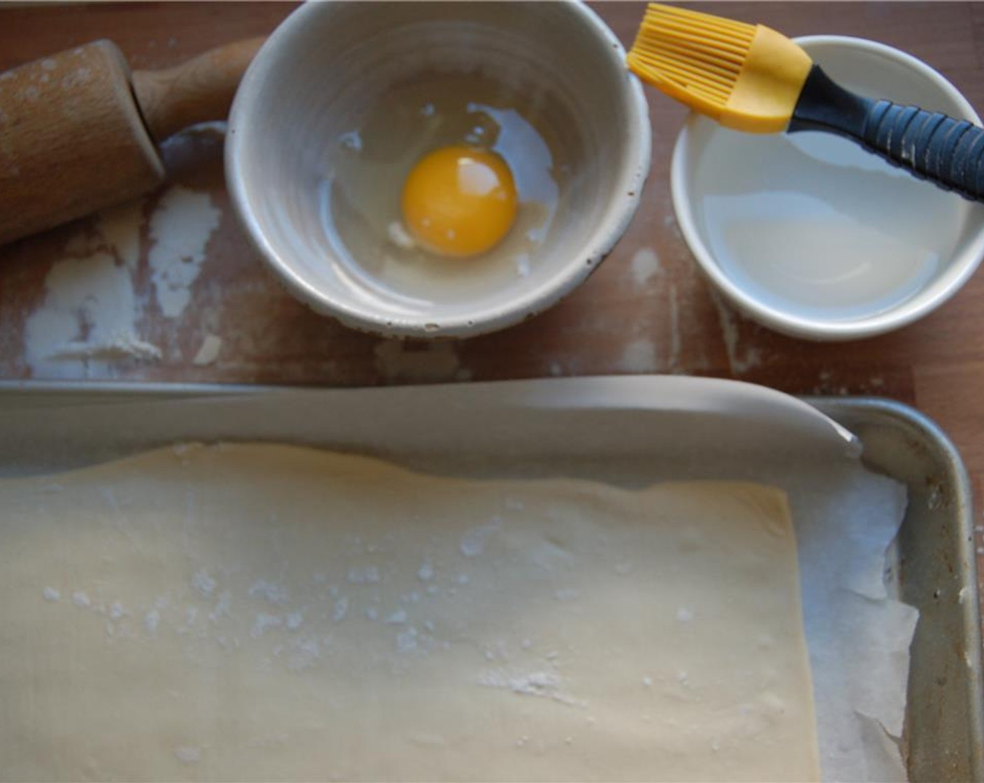 step 3 Brush edges of the pastry sheet with a bit of water.  Fold over all four sides to form a lip.