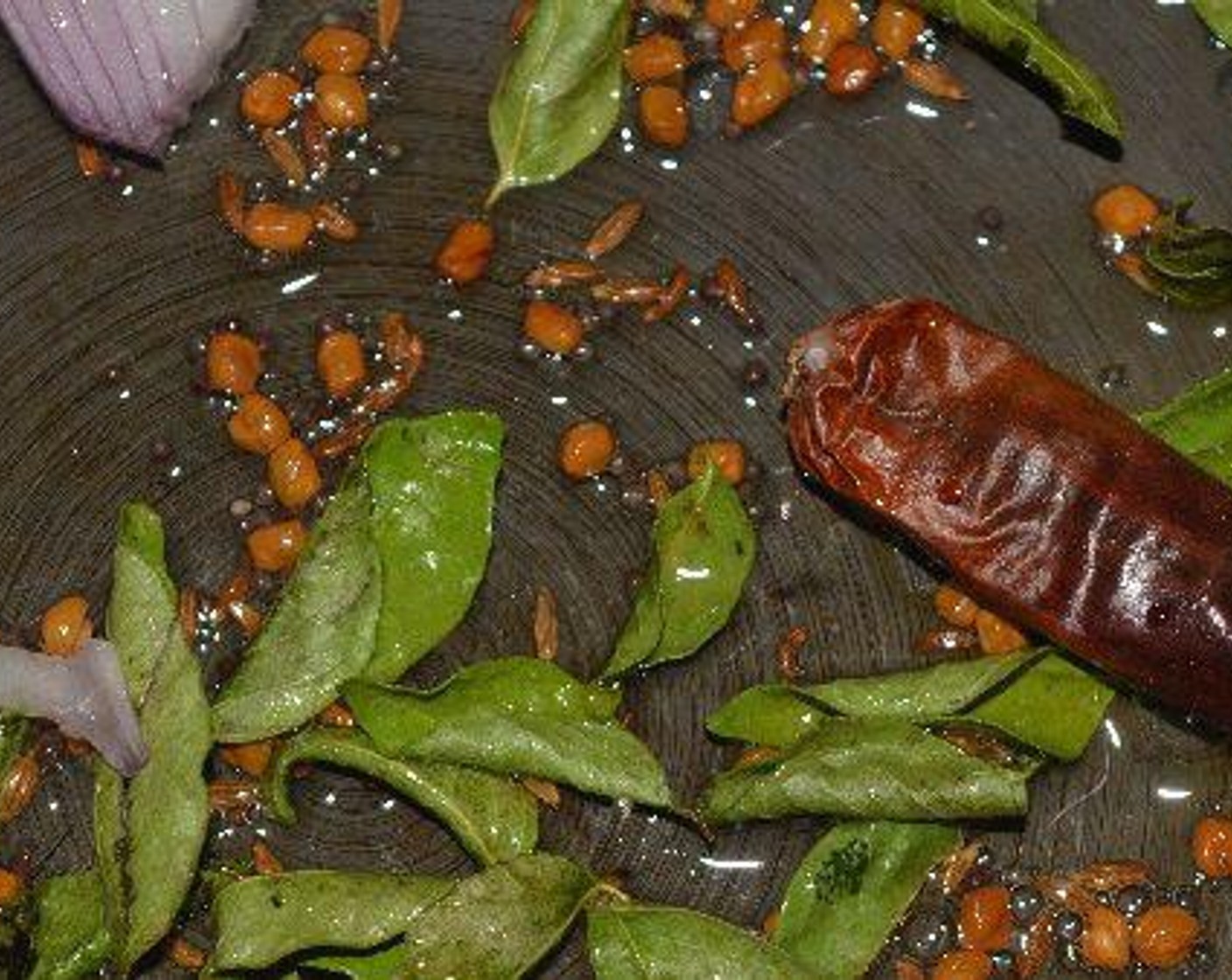 step 7 Now take a large deep pan, I used a pressure cooker, heat Vegetable Oil (as needed), add Cumin Seeds (1 Tbsp), Fenugreek Seeds (1/2 Tbsp), Mustard Seeds (1/2 Tbsp), and let them sizzle. Now add Dried Chili Pepper (1) and Curry Leaves (8).