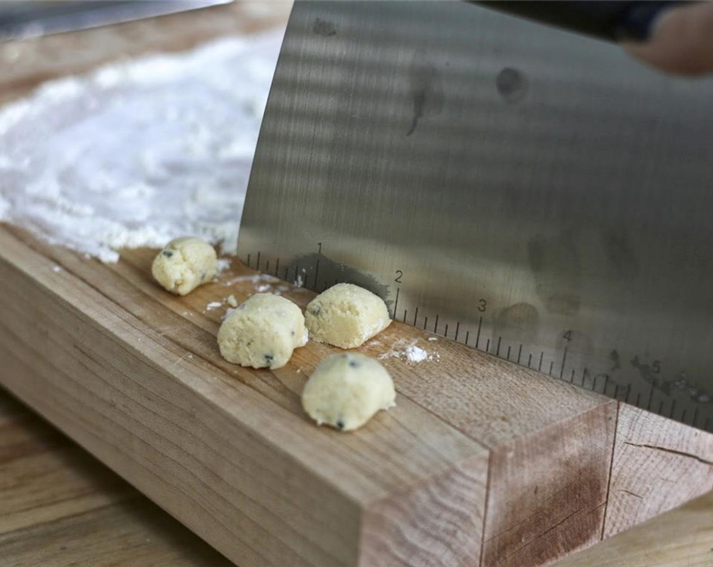 step 7 Using a bench scraper, cut the log into 3/4-inch "pillows." You can leave them as is or shape them into grooved gnocchi by rolling them off the back of a fork. Transfer this batch to the prepared baking sheet and repeat.