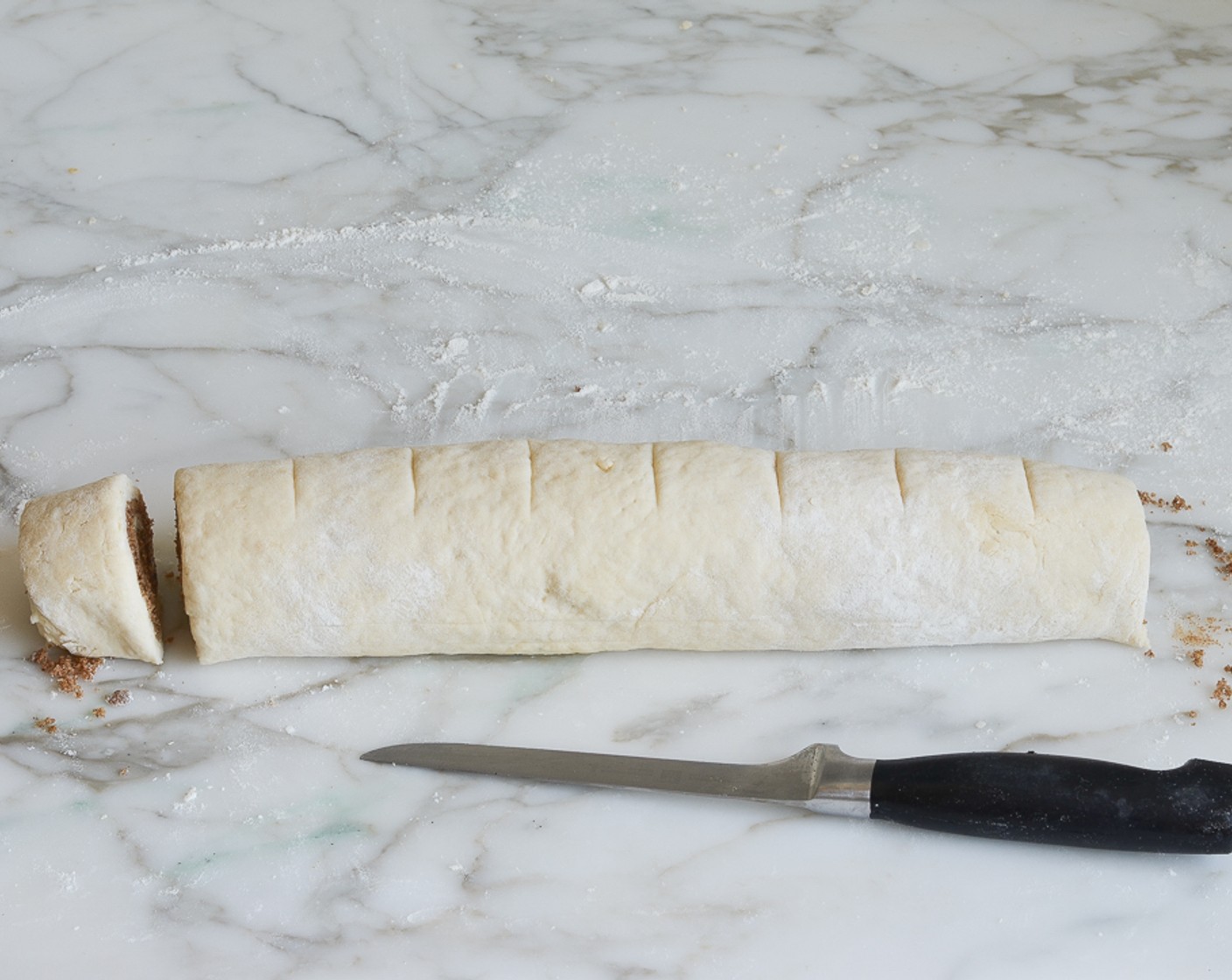 step 9 Starting at the long side, roll the dough, pressing lightly, to form a tight log. Pinch the seam to seal.