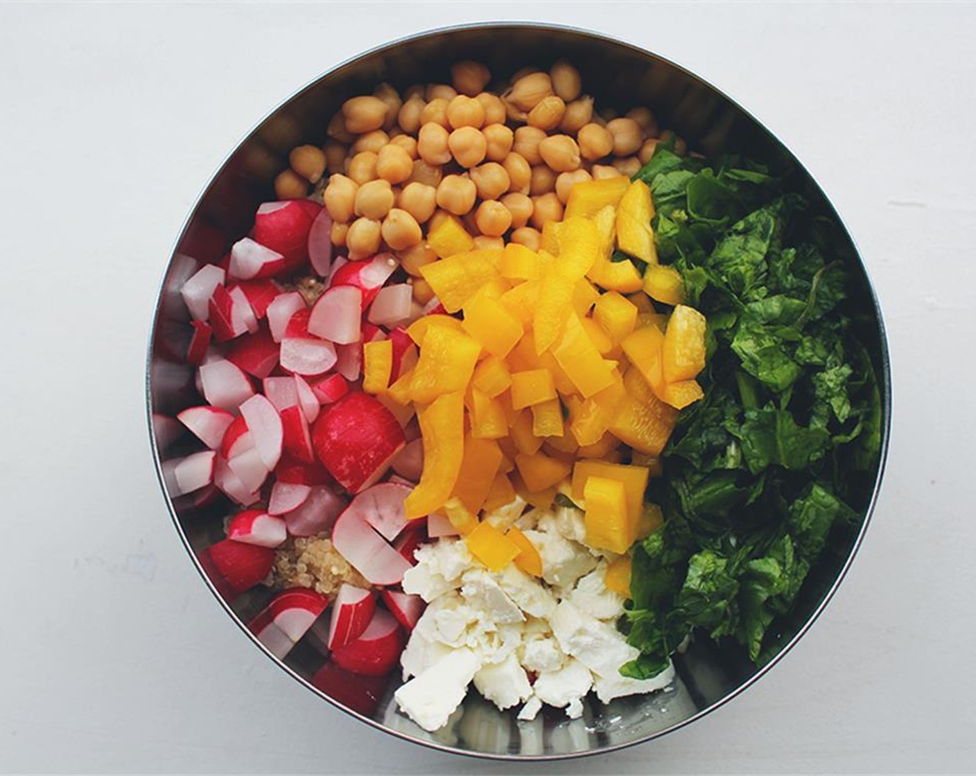 step 3 While the quinoa is bubbling away, simply chop up the Onion (1/2), Yellow Bell Pepper (1/2), Radishes (1 1/4 cups), Fresh Spinach (1 handful), Feta Cheese (2/3 cup). Add GOYA® Chick Peas (1/2 cup).