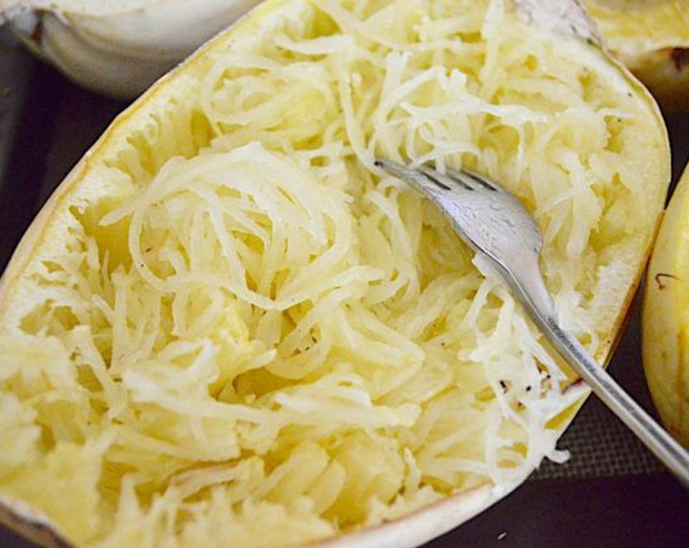 step 7 Scoop all of the "spaghetti" out of the squash with a fork, breaking it up as you do.