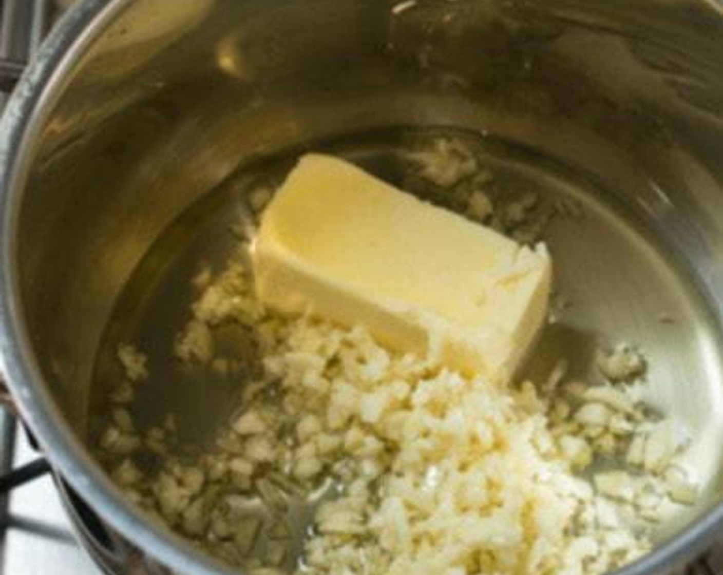 step 2 Put Salted Butter (1/3 cup), Garlic (10 cloves), Olive Oil (1/4 cup) in a small saucepan. Place the pan over low heat. Stir frequently, scraping the bottom of the pan as you stir. Continue cooking the garlic over very low heat.