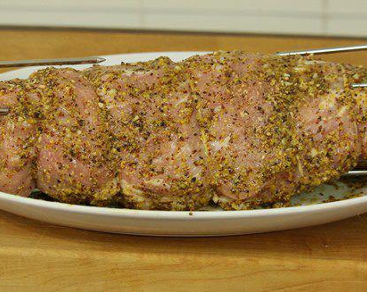 step 2 Once the pork loin is tied up and ready, it’s time to season. Stone Ground Mustard (1 cup), Honey (2 Tbsp), Garlic (4 cloves), Salt (1/2 tsp), Ground Black Pepper (1/2 tsp), and slather over pork loin. This part can get a little messy – so make sure you’ve got a nice platter to work on.