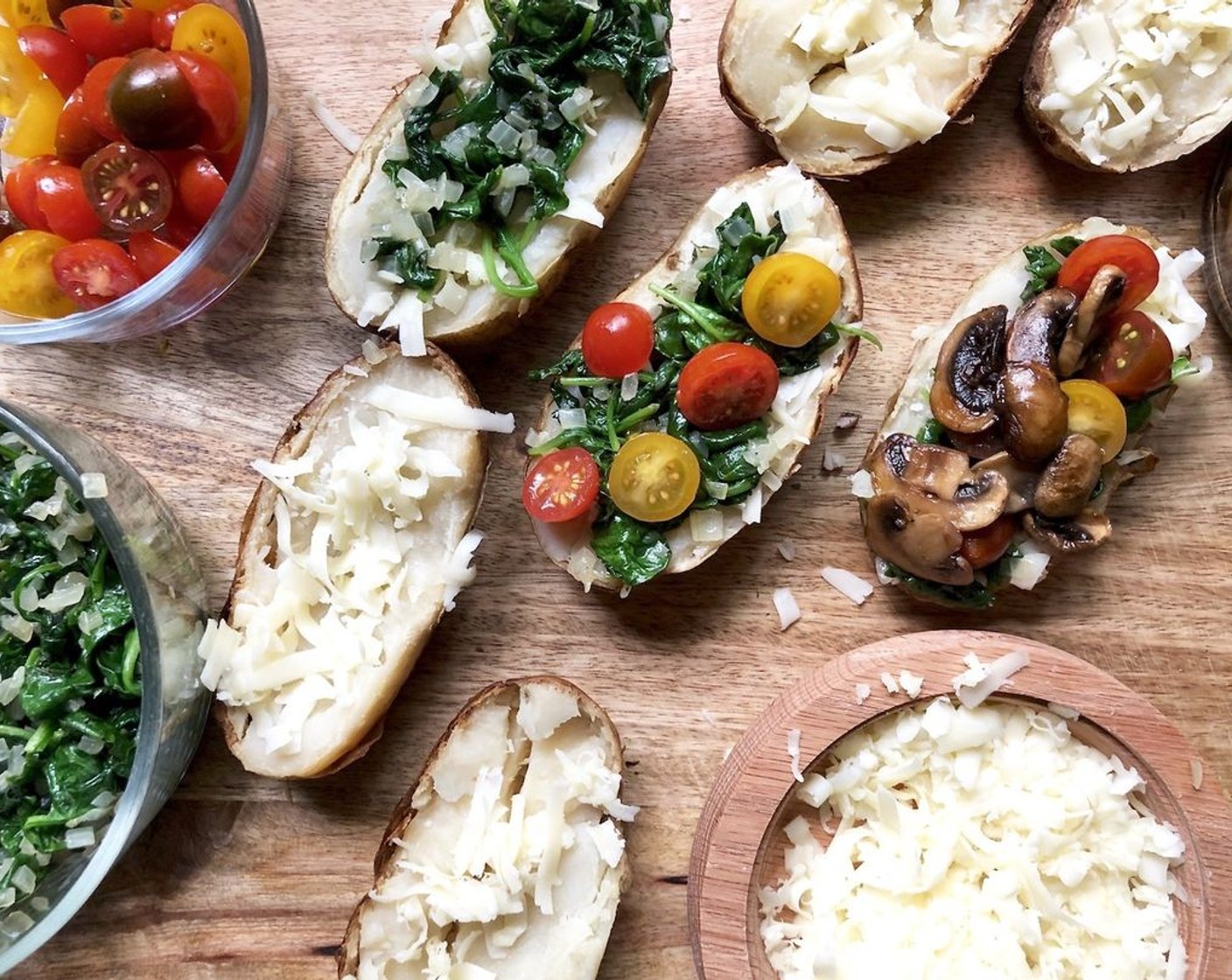 step 7 Place the potato halves on a baking sheet and fill with layers of Sharp Cheddar Cheese (1 1/4 cups), spinach mixture, glazed mushrooms, and Cherry Tomato (1 cup). Bake for about 10 minutes until the potatoes are heated through and the cheese has melted.