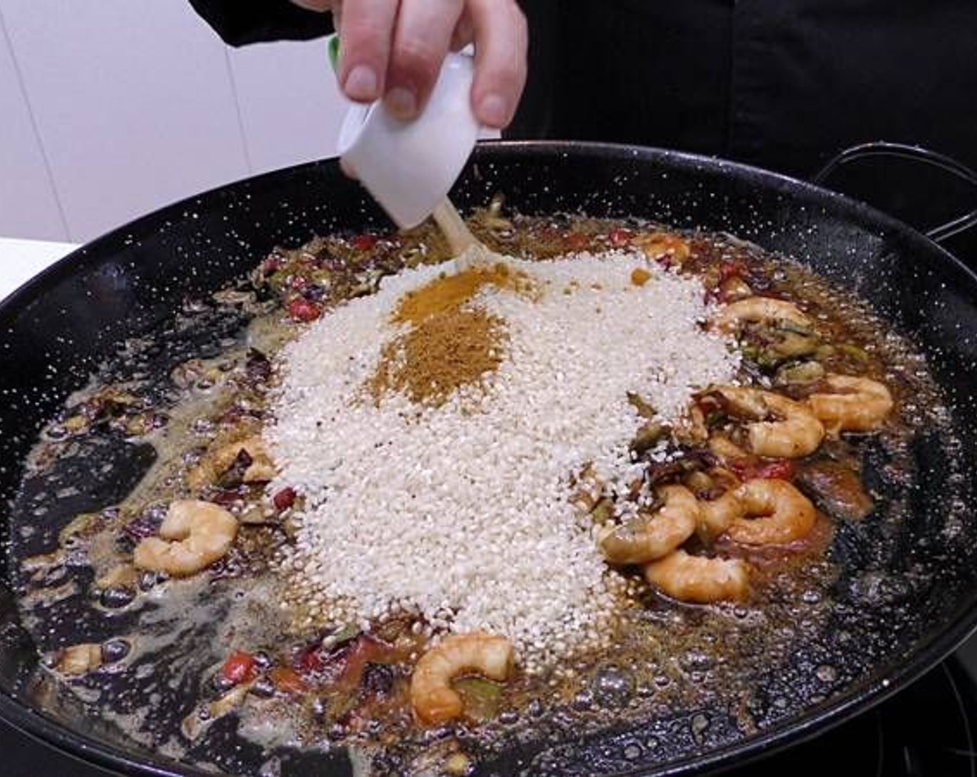 step 6 Add the Bomba Rice (2 1/4 cups), Ground Turmeric (1 tsp) and Madras Curry Powder (1 tsp). Stir the rice and cook for 1 minute.