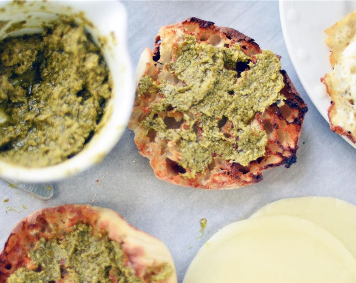 step 3 Spread 1 tablespoon of Basil Pesto (2 Tbsp) onto the top and bottom pieces of the toasted English muffin.
