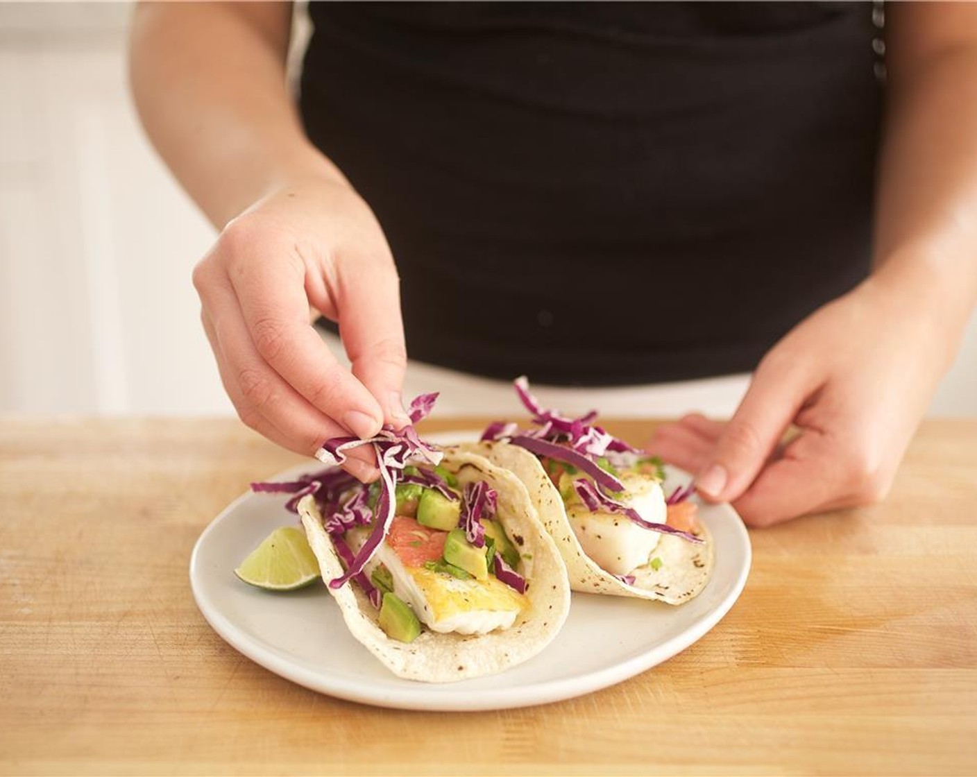 step 10 Place two tortillas side by side on each of two plates with sides touching, facing upwards. Place one halibut fillet on each tortilla and break it into several smaller pieces using a fork. Top with grapefruit salsa and Red Cabbage (2/3 cup).