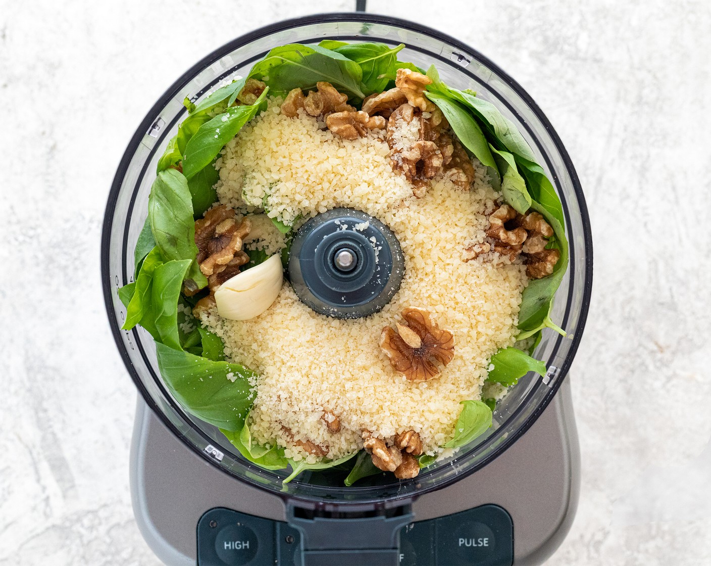 step 1 In a food processor, add Fresh Baby Spinach (4 cups), Fresh Basil Leaves (2 cups), Garlic (3 cloves), Walnut (1/2 cup), Parmesan Cheese (1/2 cup), and Kosher Salt (1/2 tsp). Process pesto by pulsing 5 to 7 times to help break down the leaves and garlic.