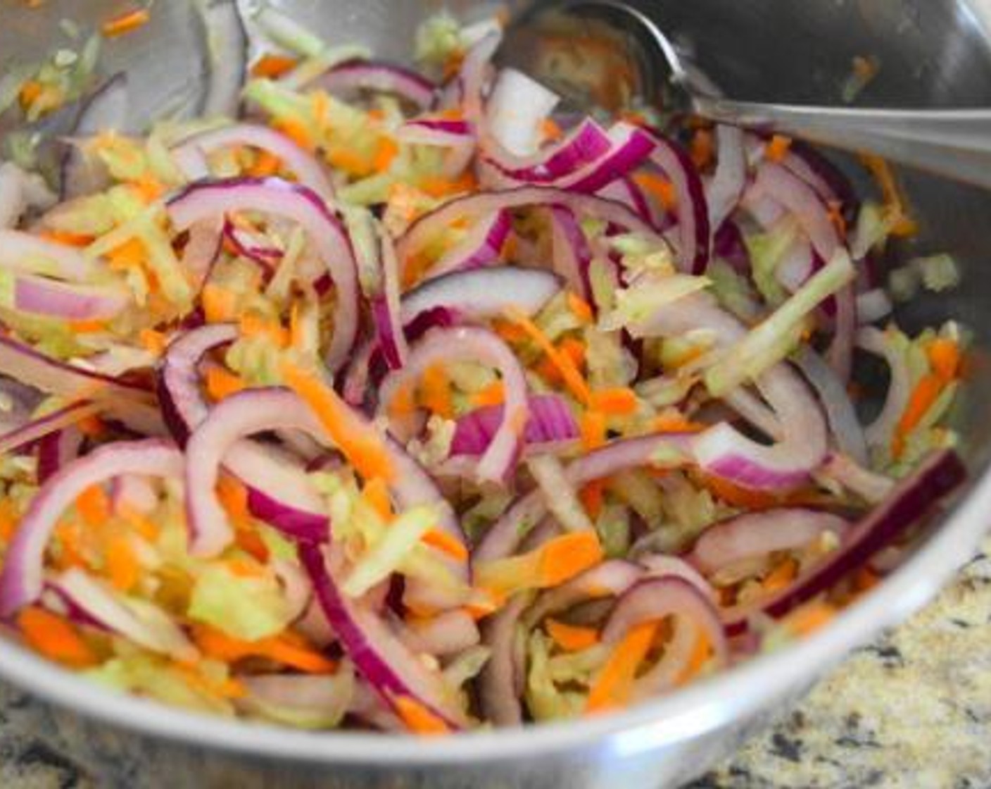 step 1 First, prepare the Asian Slaw. Combine the sliced Red Onion (1), Carrot (1), Cucumber (1), Salt (1 pinch), zest and lime of the Lime (1), and Soy Sauce (1/2 tsp). Stir them together thoroughly and set it aside. Let the flavors all marinate together and marry while you prepare the sauce and shrimp.