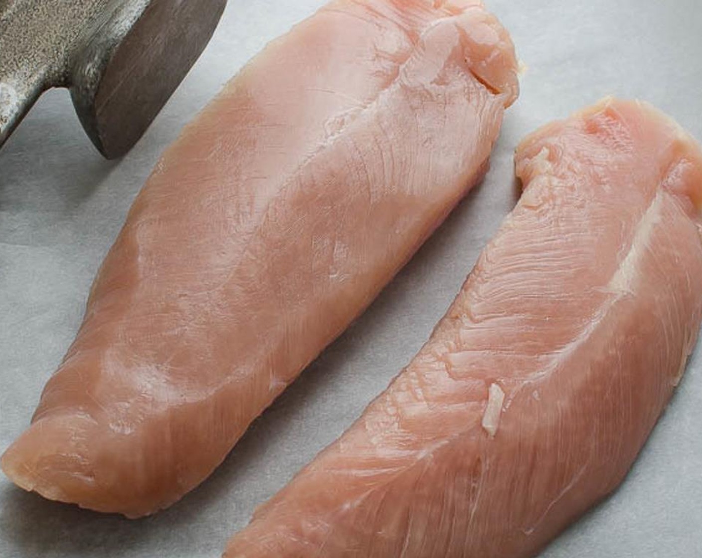 step 6 Lay a piece of parchment paper on a flat, solid surface and one at a time, place one Turkey Tenderloins (2) in the center. Place another piece of parchment on top of the tenderloin.