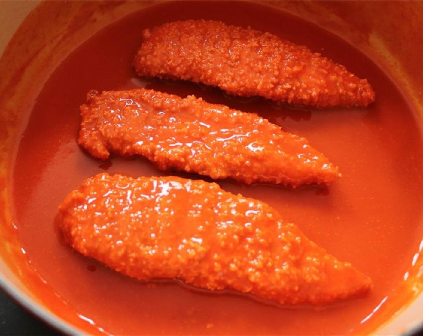 step 8 Heat the Frank's® RedHot® Sauce (1 cup) in a pan. When hot, remove from the heat and add a few chicken tenders at a time. Use tongs to make sure they get completely coated in the sauce.
