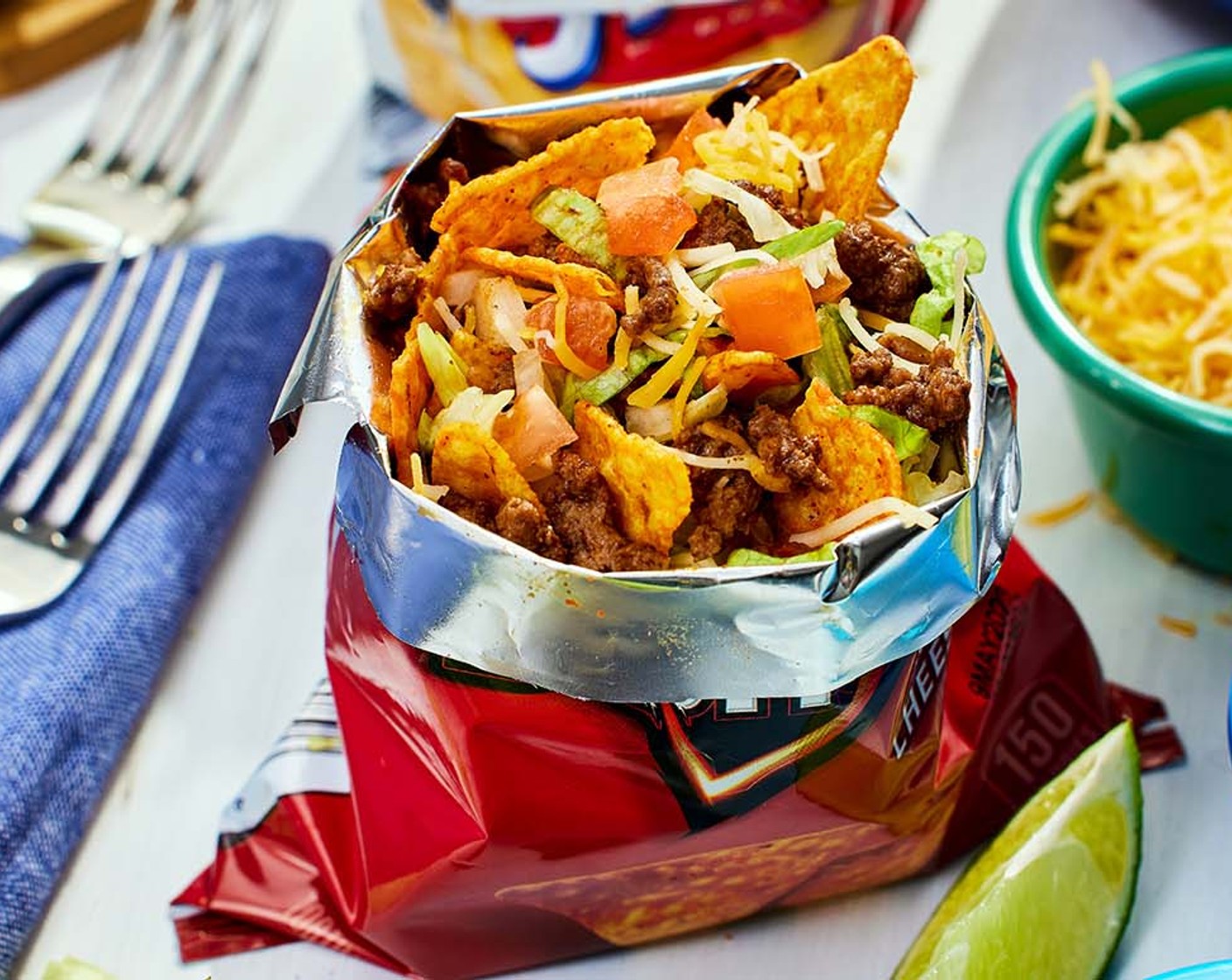 step 3 To assemble the walking tacos, open the Tortilla Chips (10 bags) and spoon about 1/4 cup of taco meat into each bag. Add your desired toppings such as shredded lettuce, chopped tomatoes, shredded cheese, chopped avocado, salsa, sour cream, and cilantro. Serve with a fork.