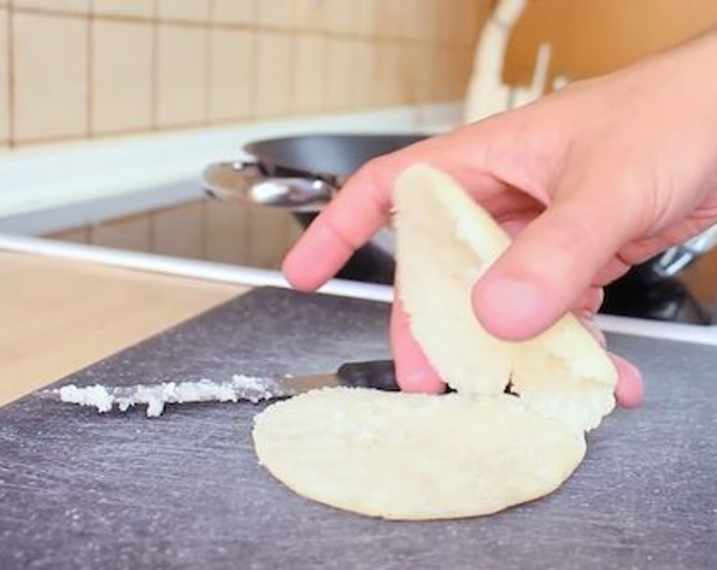 step 6 When you see a golden crust formed on both sides, the arepas are done. You should be able to tap them and hear a hollow sound. Using a knife, open the arepas 3/4 of the way so that you can fill them but still have both top and bottom remain attached.