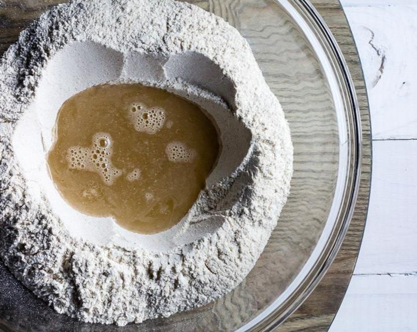 step 3 For the dough, in a separate bowl, whisk Barley Flour (5 cups) with Fine Salt (1 tsp). Add Honey (3 Tbsp) to Water (8 fl oz), stirring until combined. Make a well in the flour and add the honey water to the well.