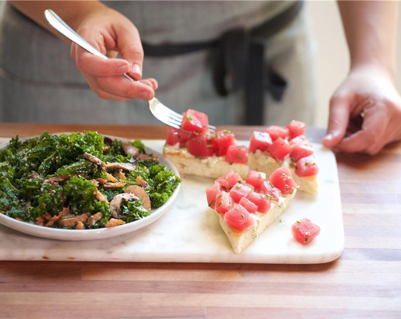 step 11 In the center of two plates, place the brioche. Evenly spread the basil aioli amongst the bread slices. Place the ahi tuna directly over the bread and garnish with chopped basil. Place the kale salad on the side and garnish with remaining Parmesan Cheese (4 Tbsp) and a pinch of pepper.