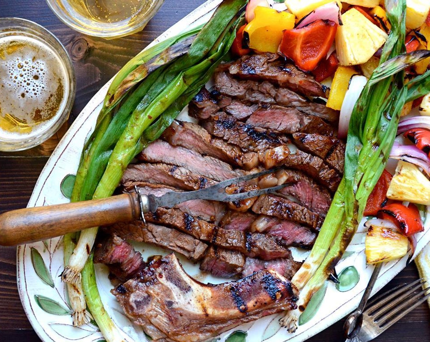 step 15 Slice the steak into 1-inch slices and arrange on a platter. Pour any collected juices back onto the meat. Slide the vegetables from the skewers and arrange on the platter along with the grilled onions. Serve.