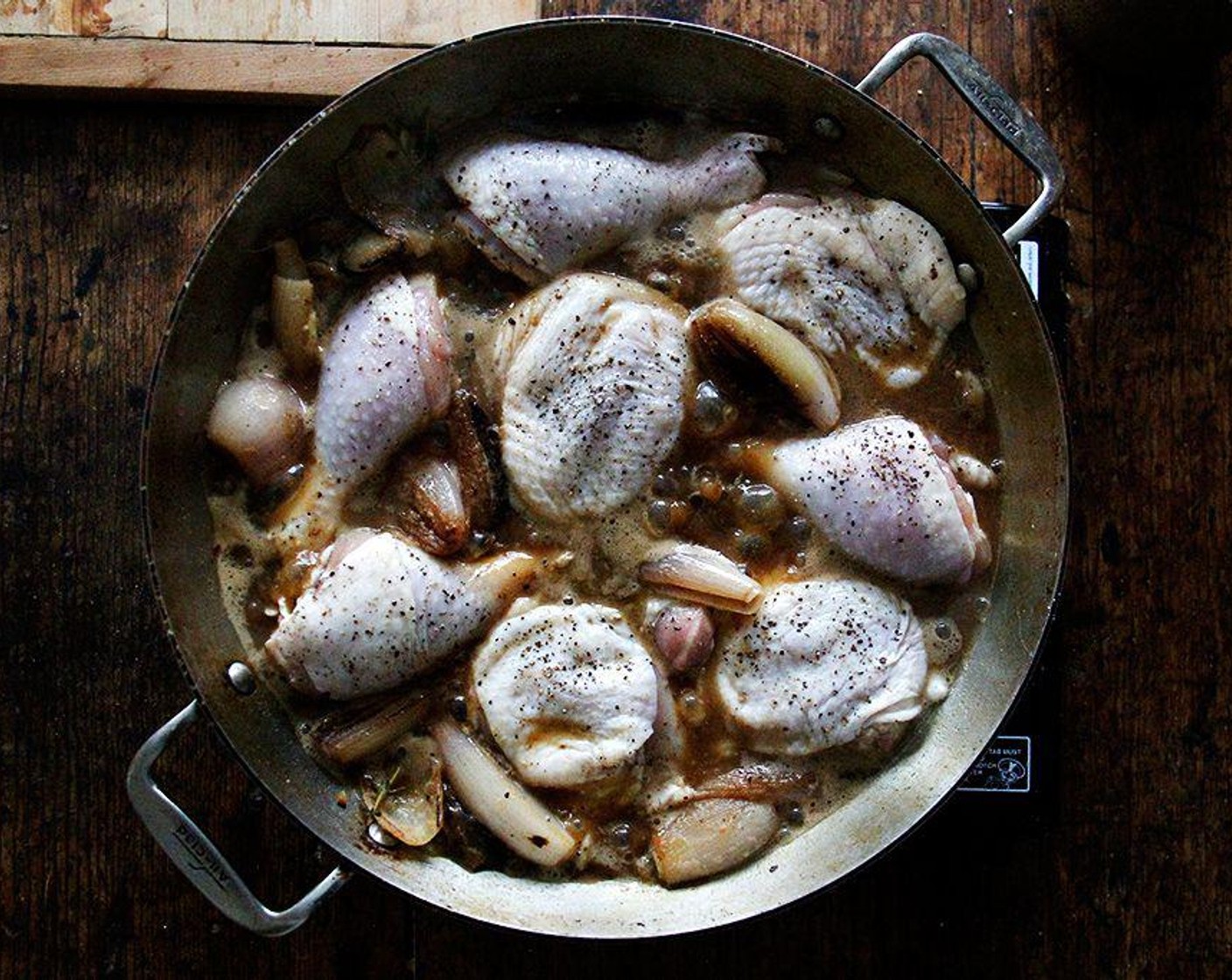 step 5 Meanwhile, season the Bone-in, Skin-on Chicken Thighs and Drumsticks (8) generously with Kosher Salt (to taste) and Freshly Ground Black Pepper (to taste) on both sides. When the wine simmers, add the chicken pieces to the pan and transfer the pan to the oven. Cook for 40-50 minutes, or until the skin is nicely brown and crisp. Remove pan from oven.