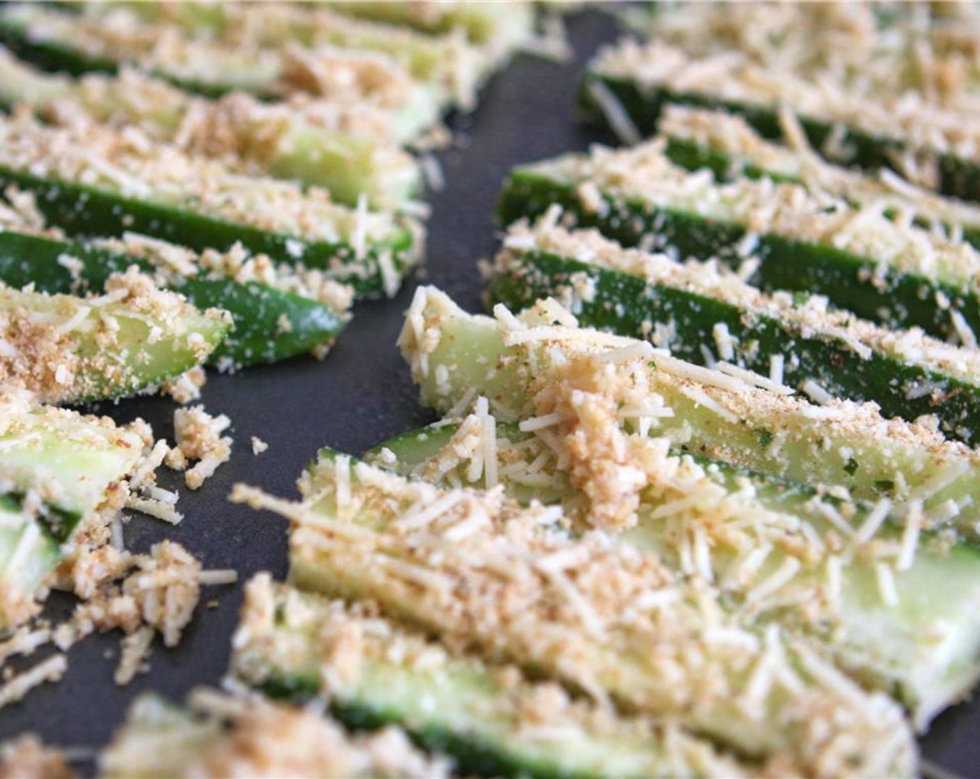 step 6 Place the coated zucchini strips onto the prepared baking sheet. Bake in the preheated oven for 20 to 25 minutes, or until crispy and golden brown.