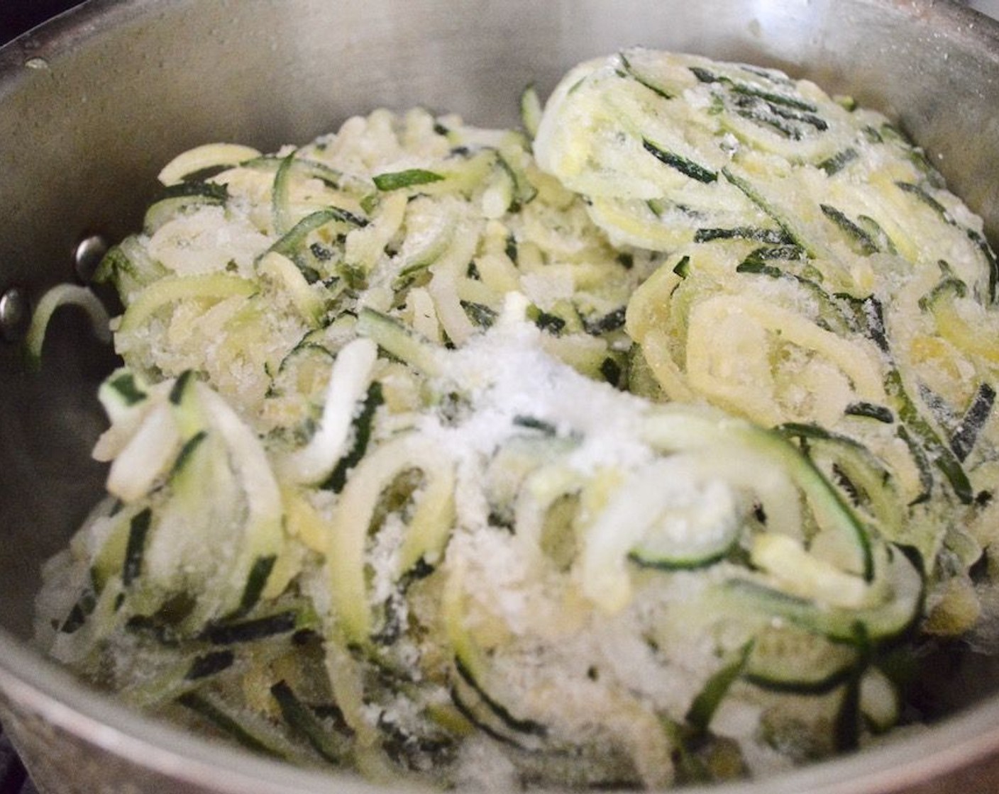 step 4 While the sauce cooks, get out a large stock pot and heat the Olive Oil (1 dash) in it over medium high heat. Place Frozen Zucchini Spirals (3.8 lb) into it and season with Salt (1 pinch). Put the lid on the pot and let the zoodles cook for 15 minutes, stirring it every so often.
