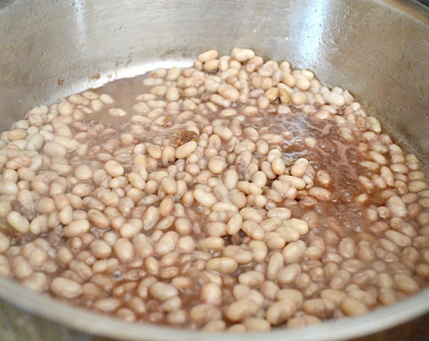 step 3 Pour in the White Beans (1 can) and Red Wine (1/4 cup), using the spoon to scrape up any brown bits at the bottom of the pan as the wine deglazes it. Let the beans, garlic, and wine cook together for a couple of minutes.