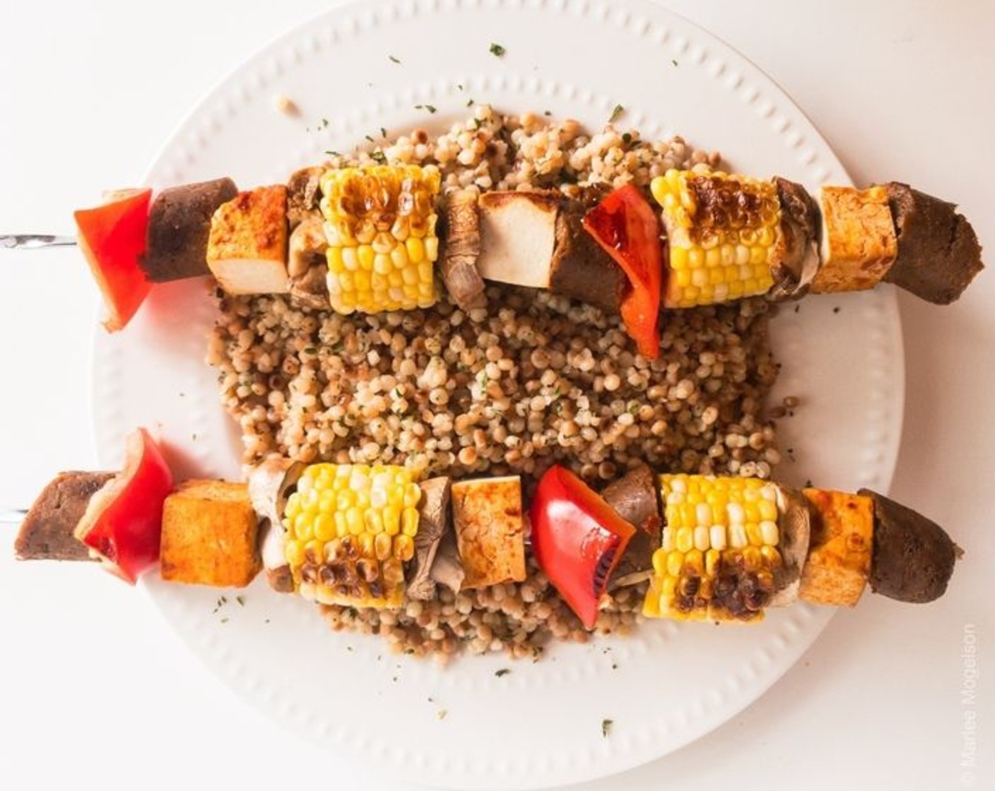 step 4 Add 3 pieces of Tofu (1 pckg), 3 pieces of Vegetarian Italian Sausage (1), 2 corn pieces, Onion (1/2 cup), and Mushroom (1/2 cup) as desired to each skewer. Cook on an outdoor or indoor grill, in a broiler, or in a pan until done, rotating as needed.