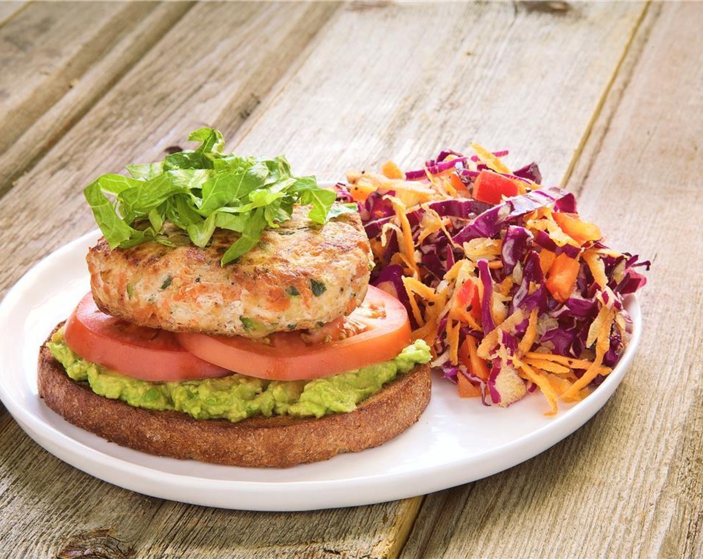 step 14 Place the burgers in the center of two plates. Serve with the sweet and tangy coleslaw.