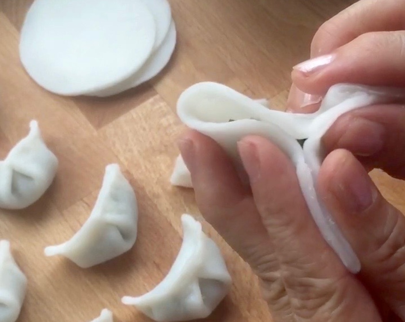 step 21 Next, pinch the lower half (left side) of chive dumpling to seal.