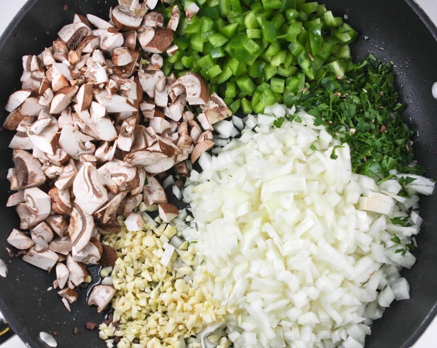 step 2 Don’t clean the skillet. Heat the Extra-Virgin Olive Oil (1/3 cup) over medium heat in the same skillet and add the Garlic (8 cloves), Yellow Onions (2), Green Bell Pepper (1), Mushrooms (2 1/4 cups) and Italian Flat-Leaf Parsley (4 Tbsp).