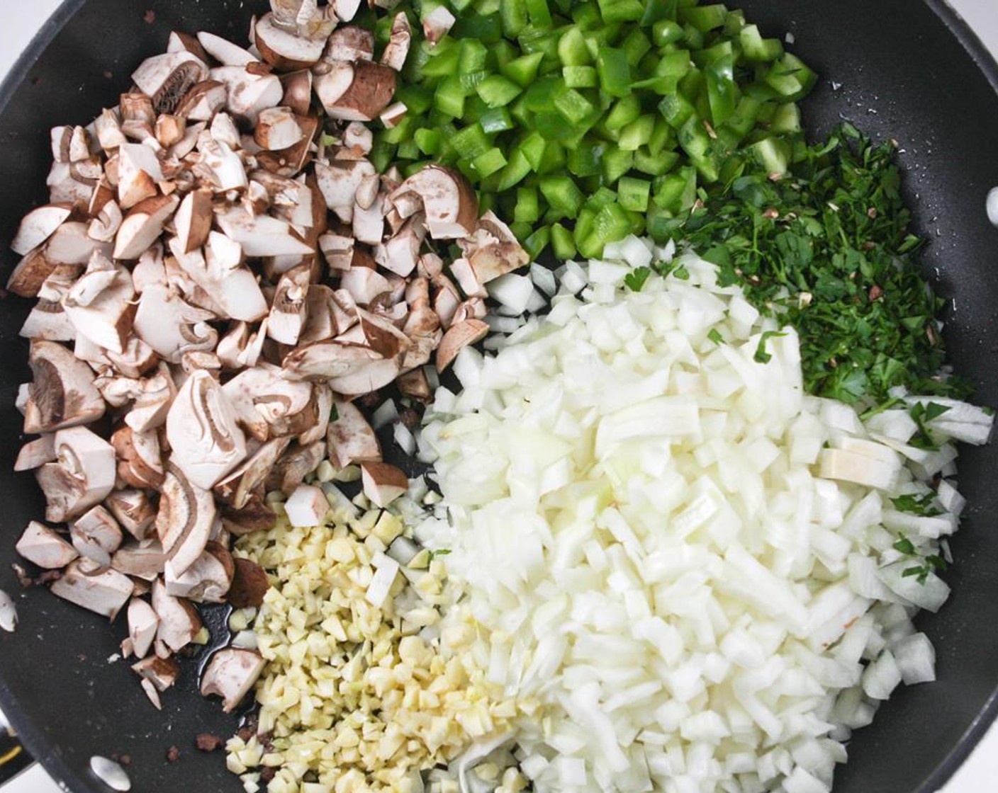 step 2 Don’t clean the skillet. Heat the Extra-Virgin Olive Oil (1/3 cup) over medium heat in the same skillet and add the Garlic (8 cloves), Yellow Onions (2), Green Bell Pepper (1), Mushrooms (2 1/4 cups) and Italian Flat-Leaf Parsley (1/4 cup).