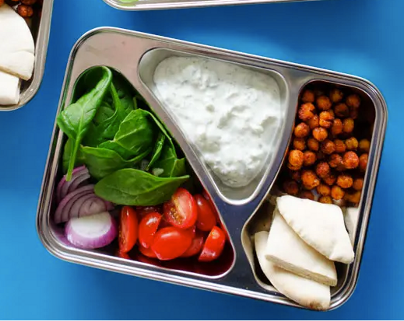 step 5 Assemble: Spoon chickpeas evenly into 4 or 5 lunch boxes. Add Pita Bread (4), Red Onion (1/4), Spinach Leaves (2 cups), Cherry Tomato (1 cup), Cucumber (1/2 cup), and sauce.