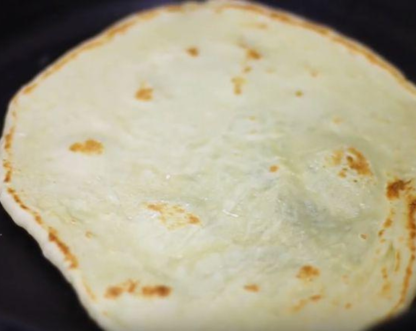 step 6 Roll out each of the six dough pieces and cook each of the naan in a cast iron skillet for about a minute on each side.