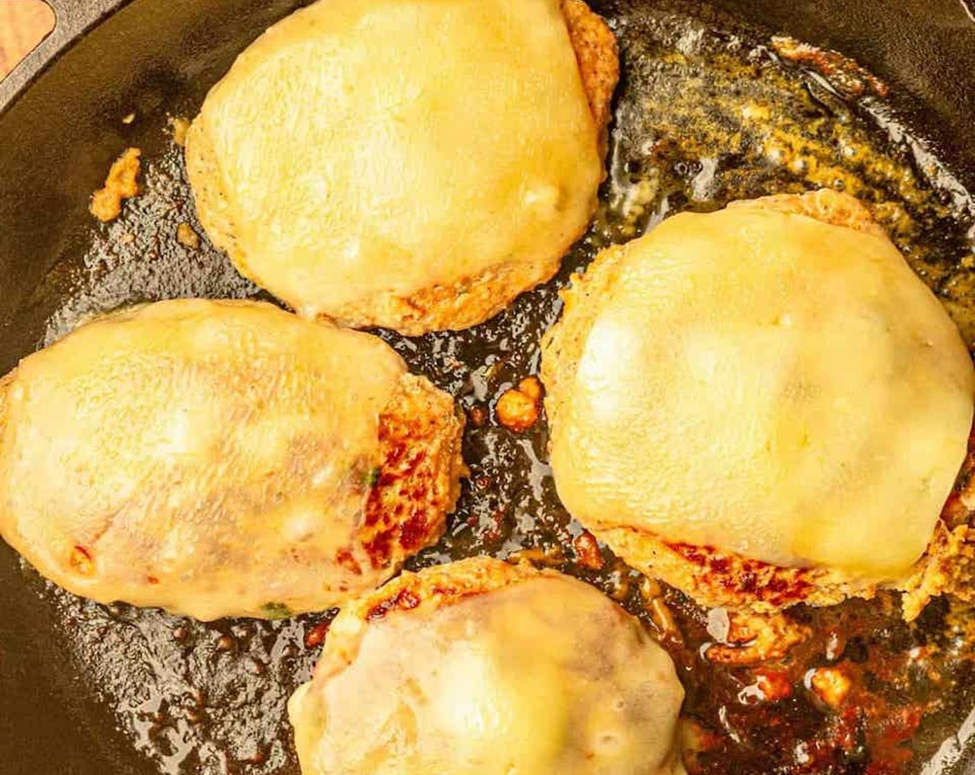 step 6 If you are using cheese, add a slice of Cheddar Cheese (4 slices) to each burger about 1 minute before they are done cooking. The internal temperature of the burgers should be at least 165 degrees F (70 degrees C).