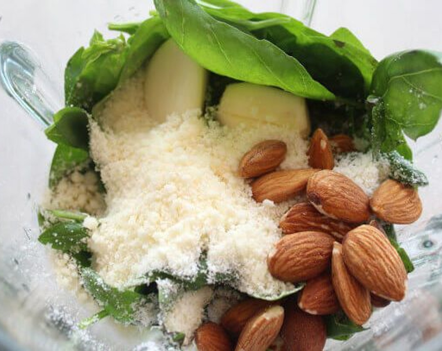 step 1 Place Fresh Basil Leaves (2 cups), Garlic (2 cloves), Grated Parmesan Cheese (1/3 cup), Almonds (1/4 cup), Salt (to taste), and Ground Black Pepper (to taste) in a blender and pulse until almost smooth. Now pour the Olive Oil (1/3 cup) (plus 2 Tbsp) in slowly, continuing to pulse the mixture until it comes together.