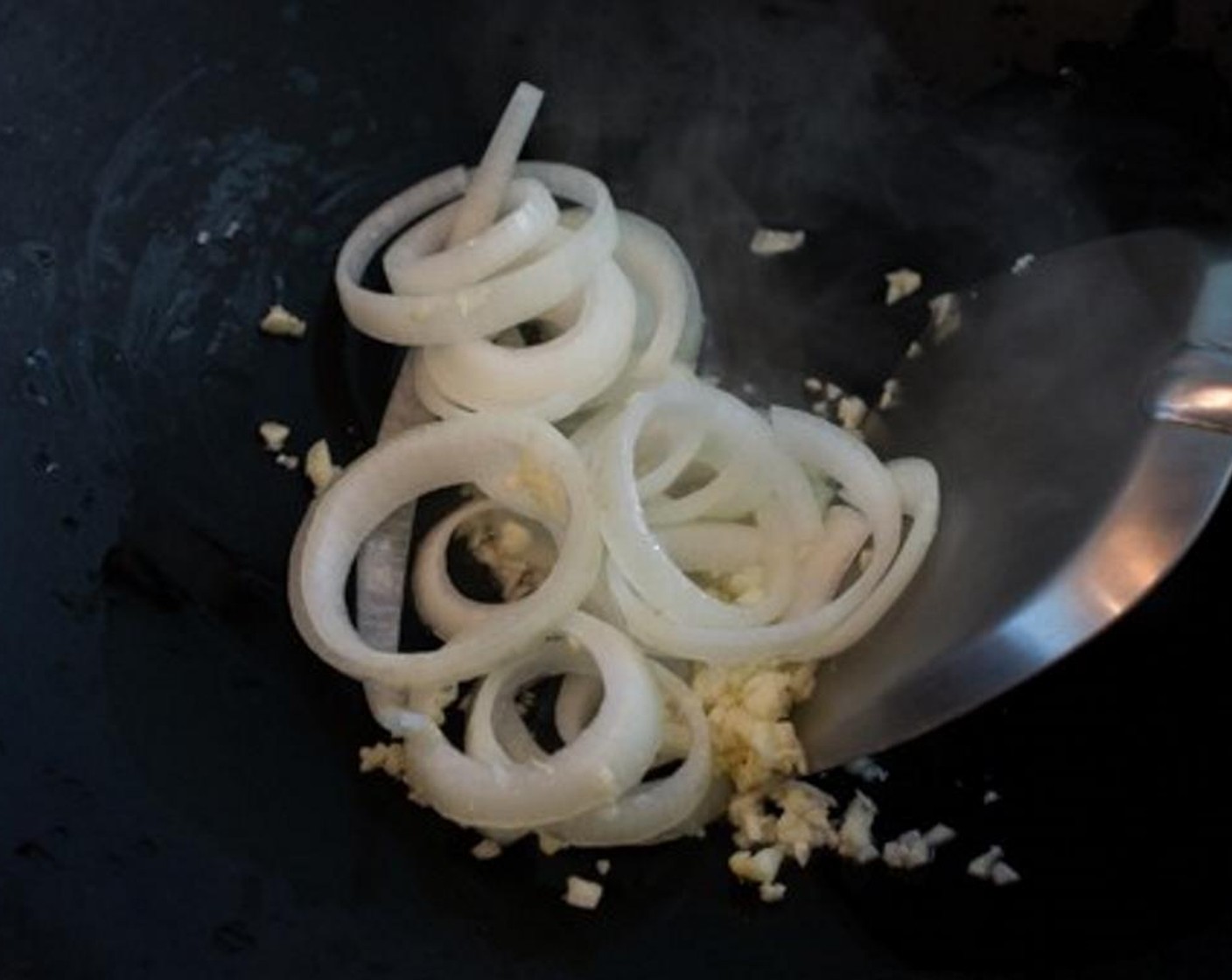 step 1 Heat up the Cooking Oil (1 Tbsp) in a wok or a large pan and saute the Onion (1) and Garlic (3 cloves) over medium-high heat.