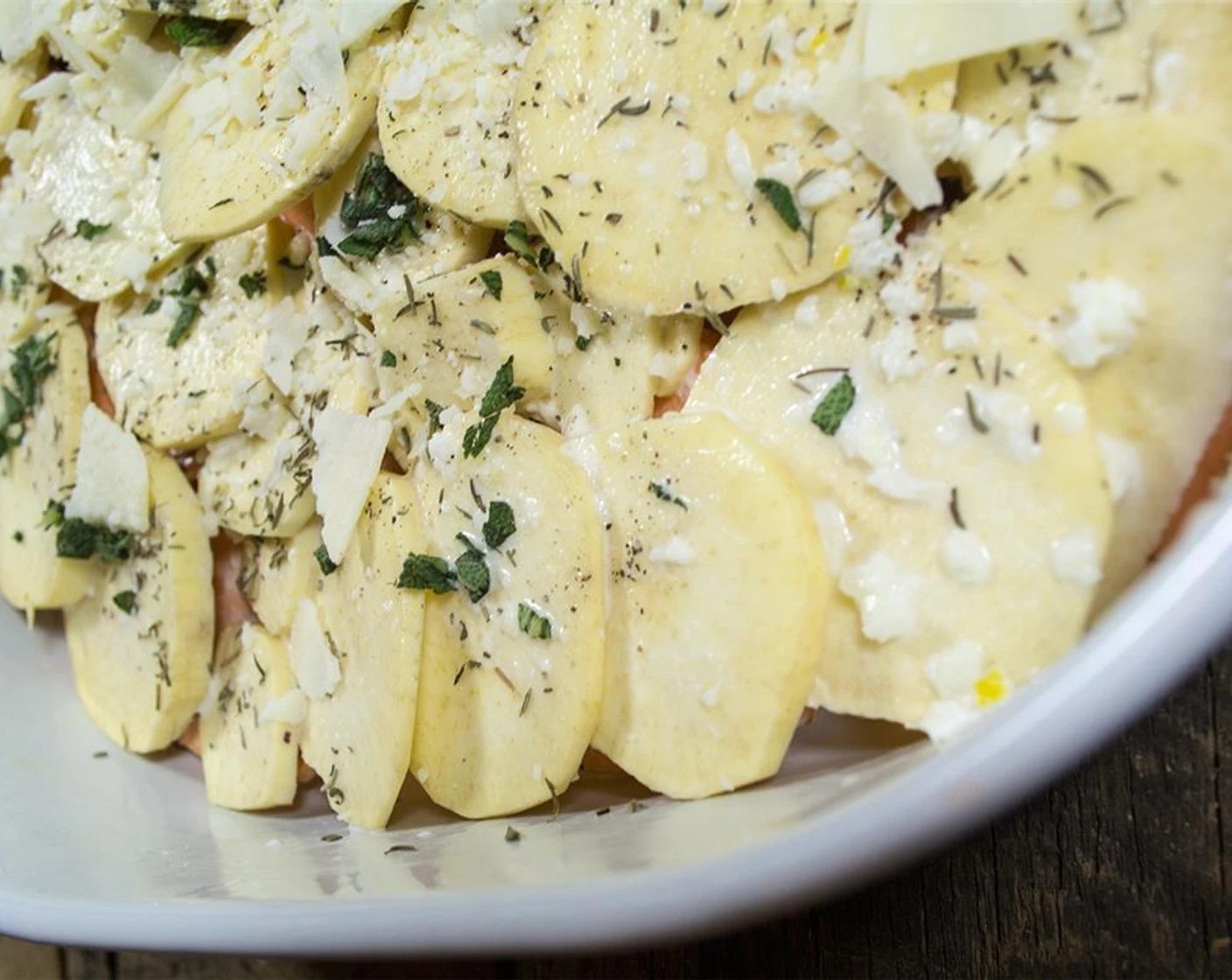 step 6 Continue the layers until you run out of potatoes. When you get to the last layer, pour the remaining cream over the top, add fresh sage, dried thyme, herbs, salt and pepper, but do not add the final layer of cheese.