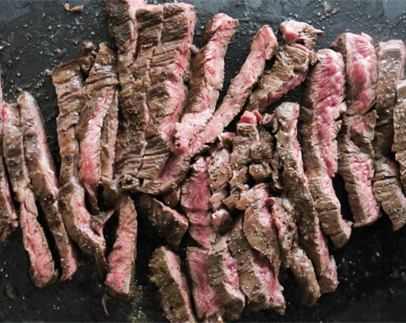 step 7 Transfer the steak to a cutting board. Let it sit for 5 minutes before thinly slicing again the grain.