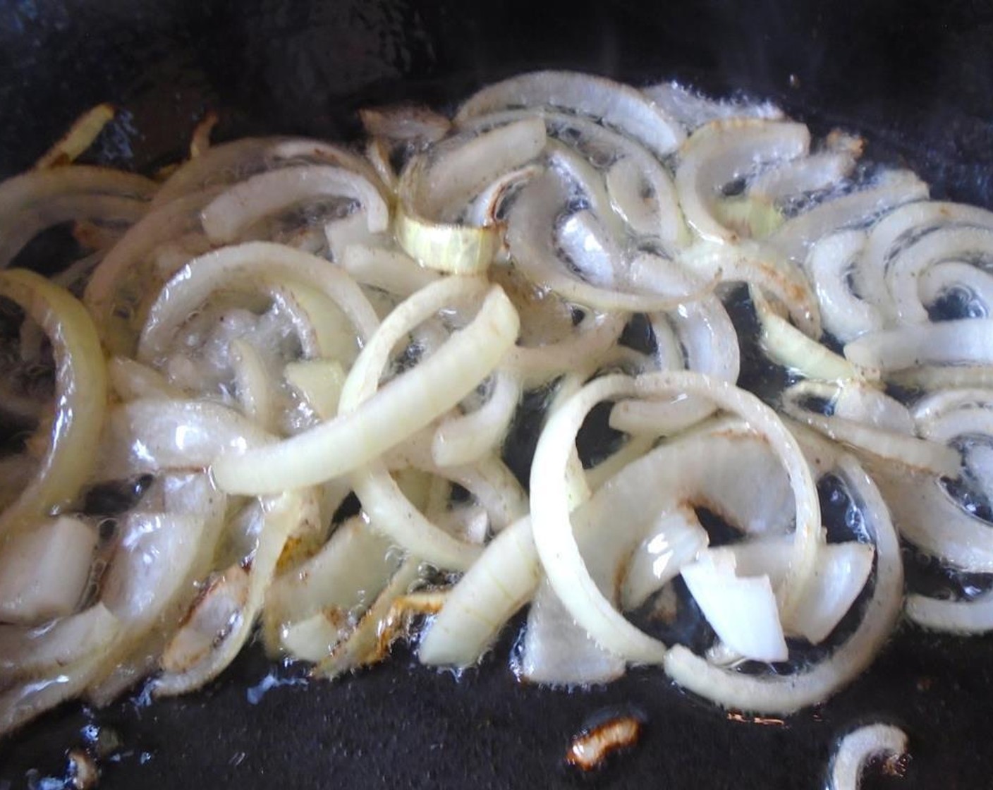 step 2 Slice the Onion (1) and saute in an oven-safe skillet Olive Oil (as needed) until translucent.