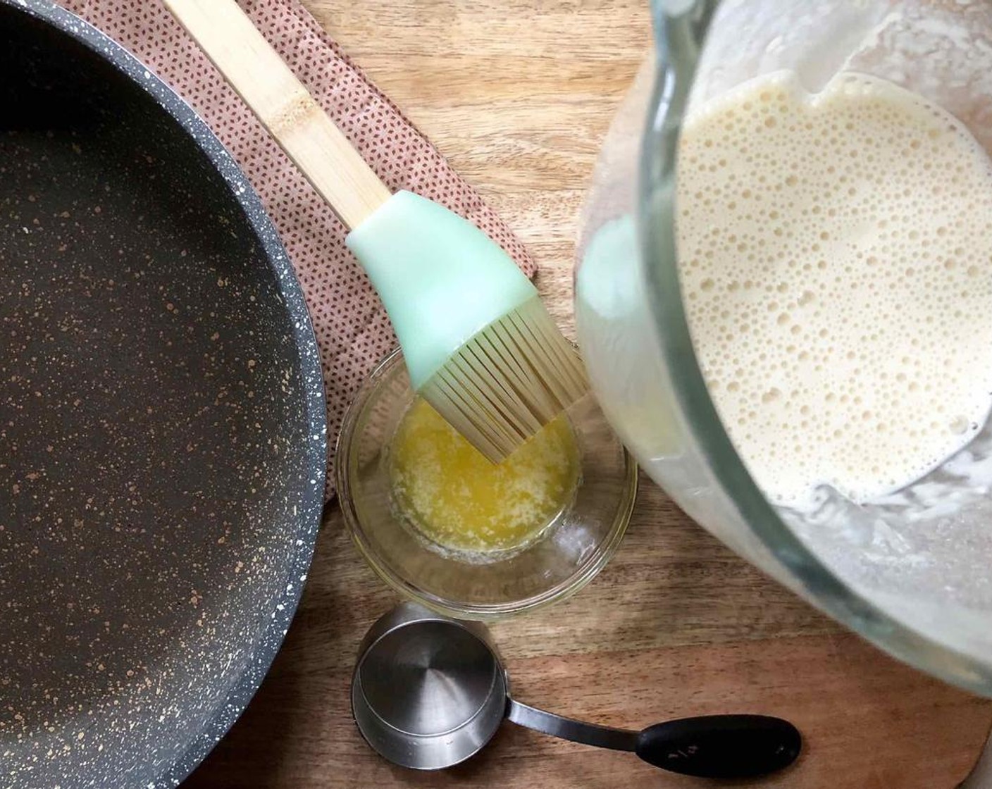 step 2 Heat a nonstick skillet over medium-high heat.  Brush with the Butter (to taste), then pour 1/4 cup of batter into the skillet, swirling the pan to coat the bottom evenly.