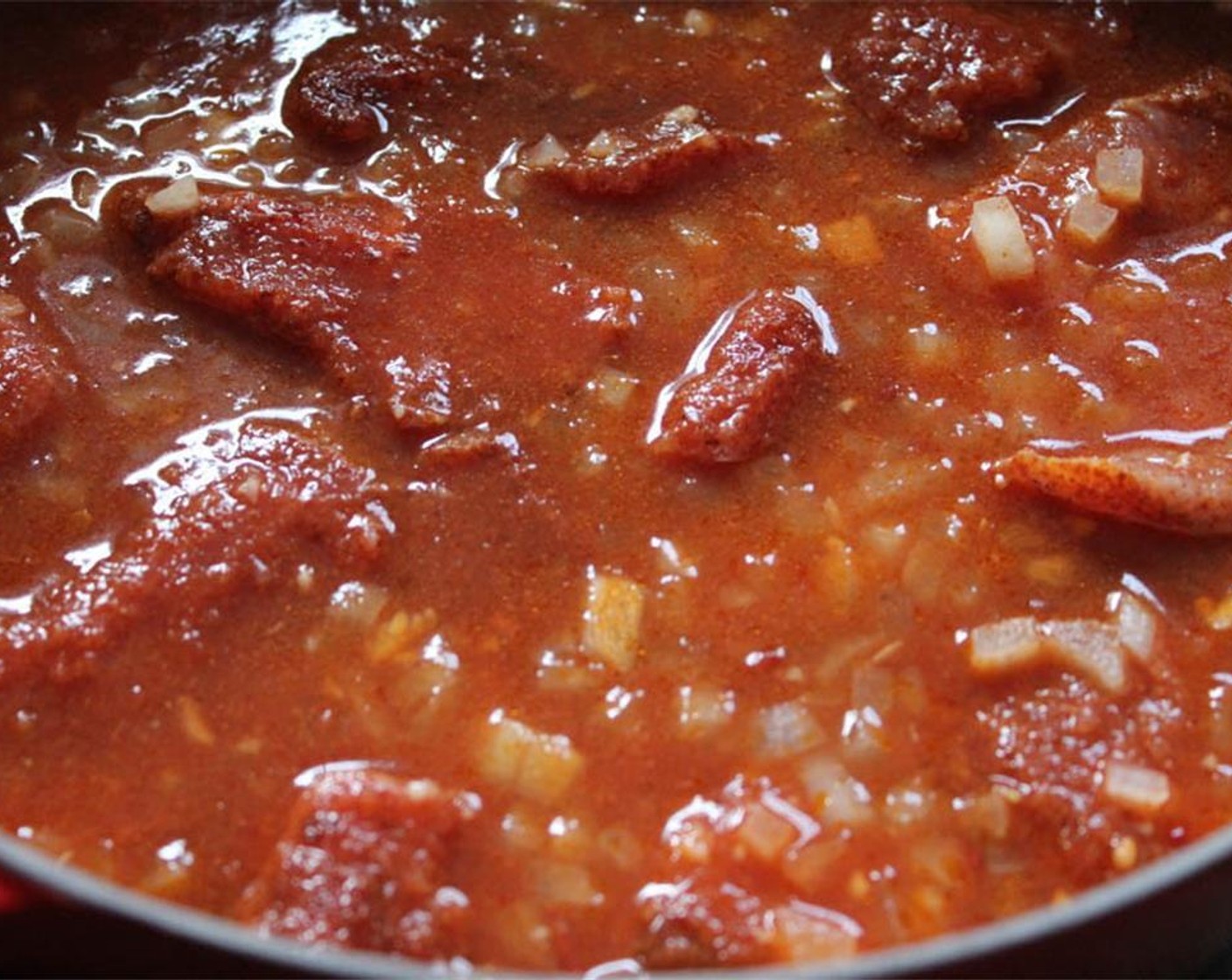 step 6 When boiling, add the spice rubbed pork to the sauce and lower to a simmer. Cover and simmer for 1 hour.