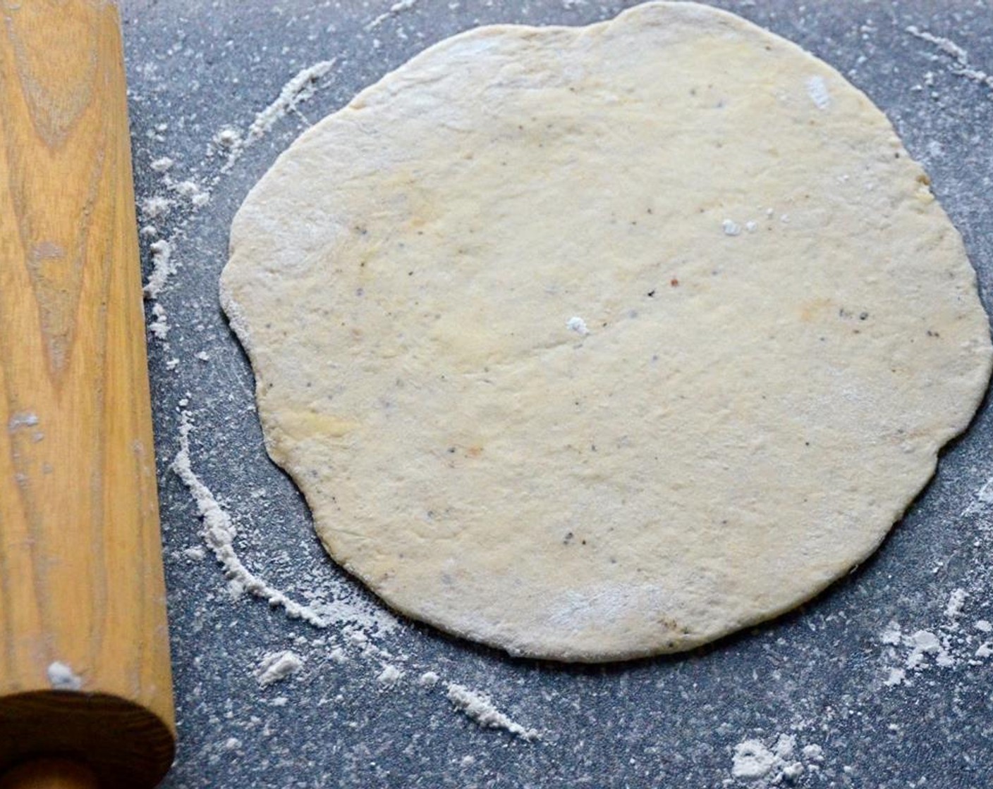 step 14 Place one ball of dough on the work surface and use a rolling pin, lightly dusted with flour to roll the dough into a disc about 1/4 - 1/3 inch thick. Set the dough onto a baking sheet and continue rolling out the other balls of dough.