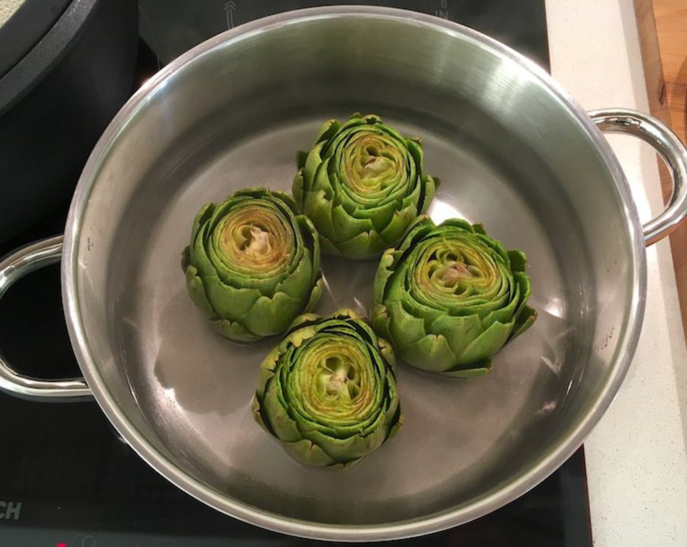 step 12 Place artichokes in a steamer basket or pot with about 1 inch of water in the bottom. Bring to a boil, reduce heat to a simmer and cover tightly with a lid to steam for about 20 – 25 minutes until the leaves pull easily from the artichoke.