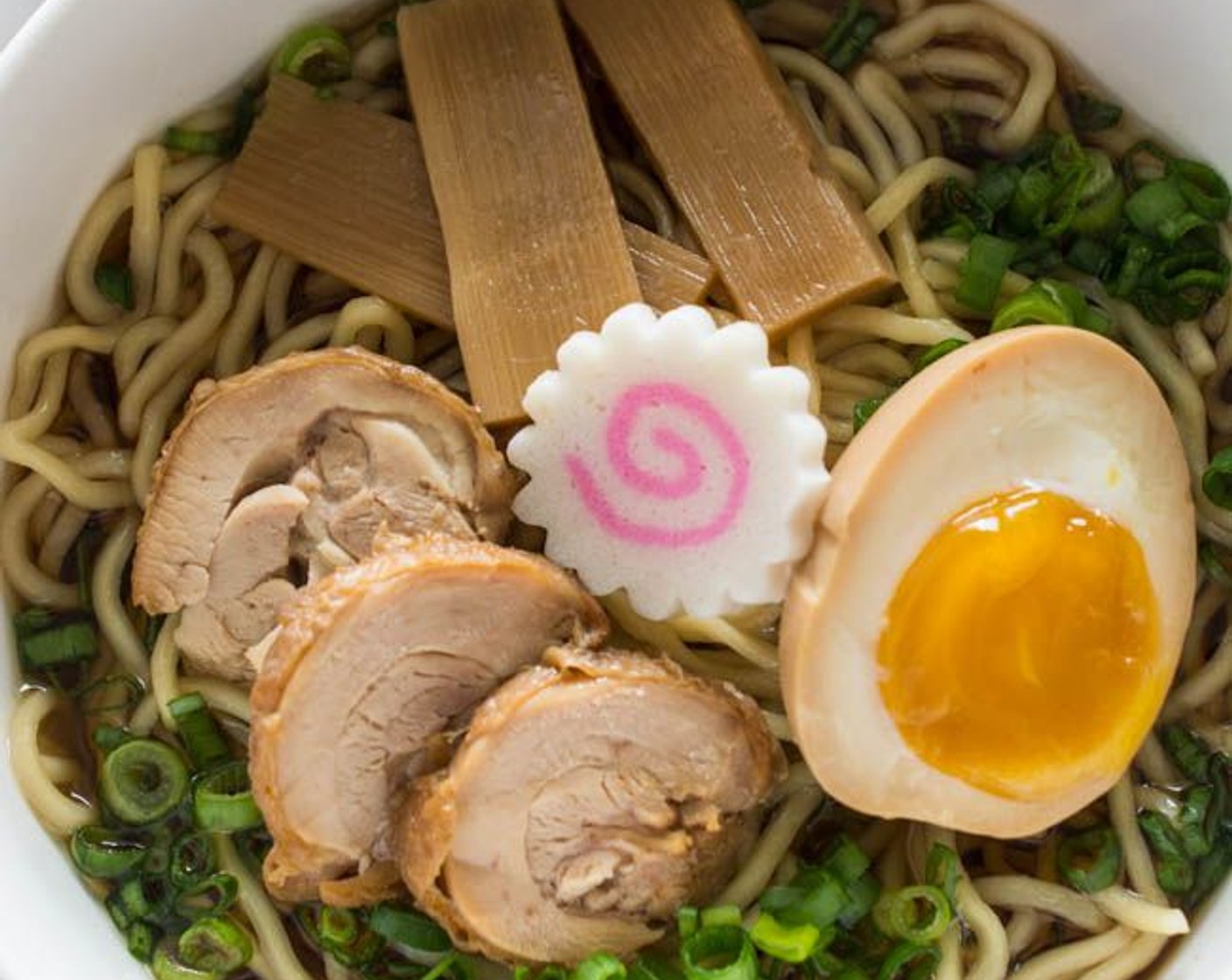 step 7 Place 1 - 2 slices of chicken chashu, Nori Sheets (4 sheets), Naruto (4 slices), Half-Boiled Ajitama (4), Menma Pickled Bamboo (12 pieces) and a sprinkle of Spring Onions (to taste) neatly on the ramen.