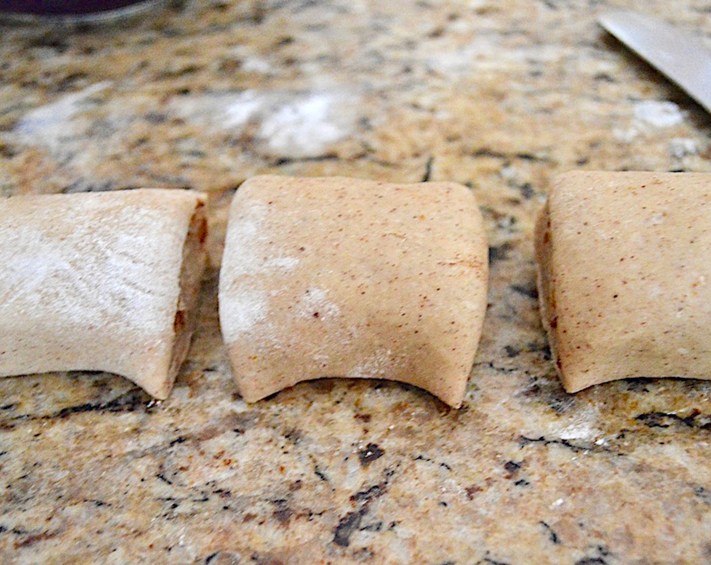 step 11 Roll it up tightly to make it a long log with the long side coming toward you. Cut the log in half, then cut each half in half. Then cut each half into three equal pieces to get 12 sticky buns total. Put 6 rolls into each pan to fill two of them, pressing them down gently into the glaze.