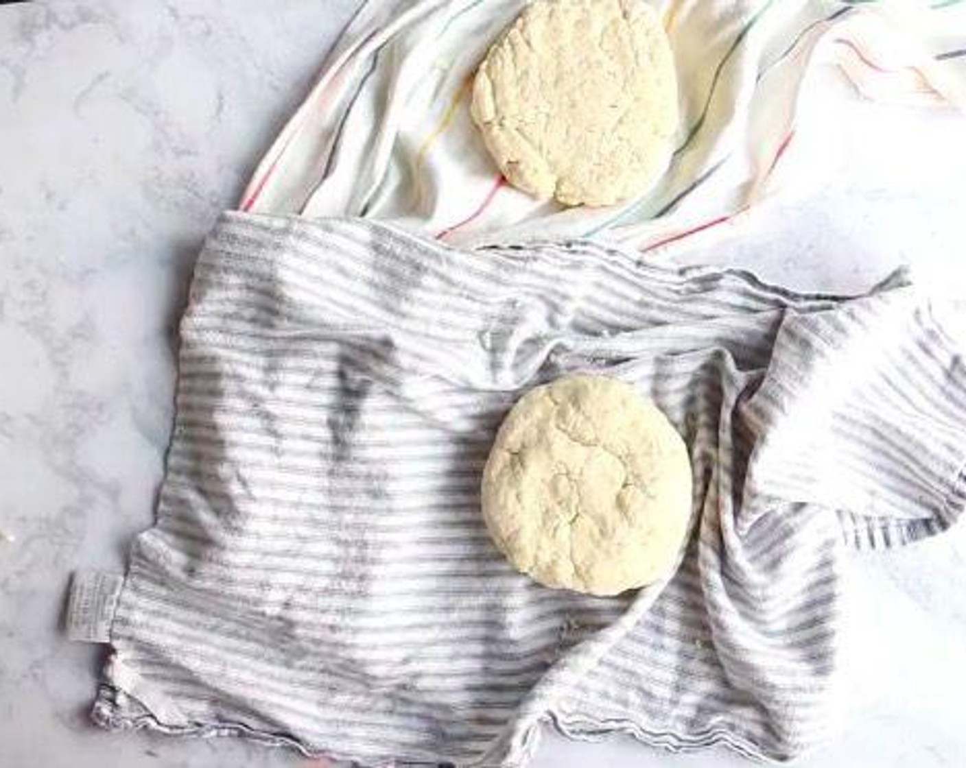 step 2 Lay two clean tea towels on a work surface. Dump half of the crumbly dough mixture into the center of each. Grab the four corners of the towel together and twist to create a beggar's purse, pressing the dough into a disk. Unwrap the towel and use your hands to pack and pat the disk together. Wrap the rounds in plastic wrap, tuck in a ziplock bag, and store in the fridge for 3 days or freezer for 3 months.