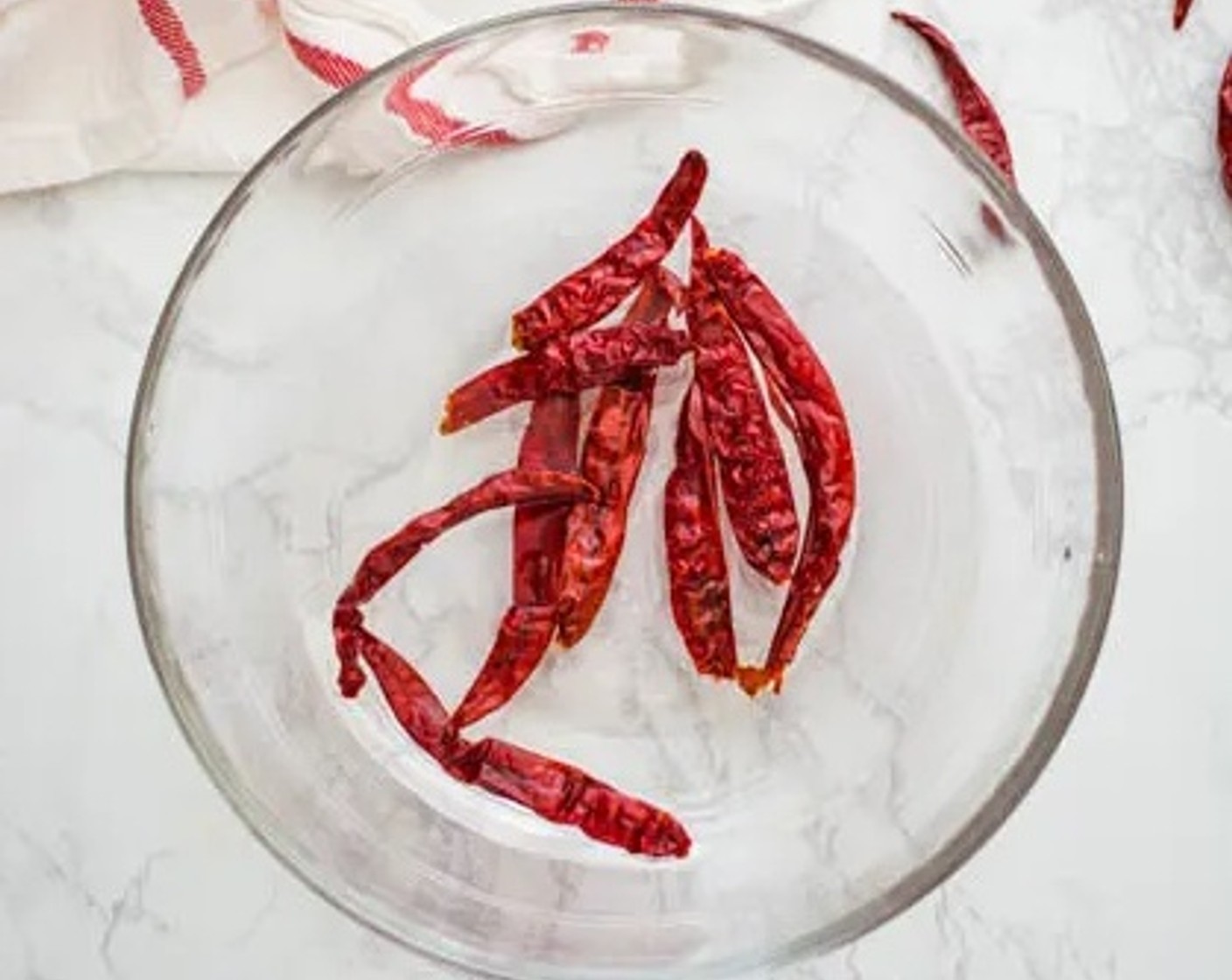 step 1 Rinse then soak the Dried Red Chili Peppers (10) in a bowl of warm water, and the Tamarind Paste (1 Tbsp) in a separate small bowl in 1/4 cup of warm water. Allow the dried red chilies and the tamarind to soak for 15 minutes.